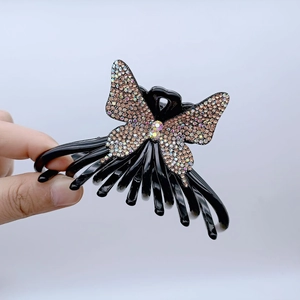 Detail of a large butterfly hair claw clip with colorful rhinestones on a black finish