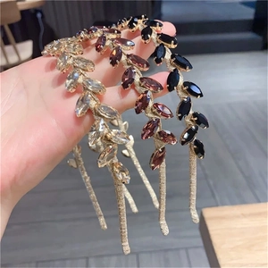 Close-up of three baroque metal headbands with leaf-shaped rhinestones in gold finish