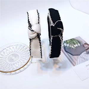 Classic Chanel-style tweed headbands in black and white with elegant top knot design
