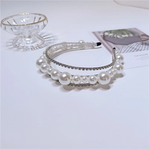 Close-up of elegant three-layer headband with shiny pearls and sparkling rhinestones