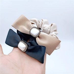 Trois chouchous élégants en satin avec nœud et perle en noir, beige et couleur champagne