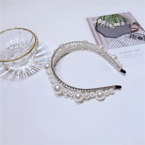 Detailed view of luxury silver headband with layered sparkling rhinestones and white pearls