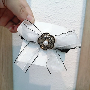 Elegant white organza bow hair tie featuring a rhinestone camellia and pearl center