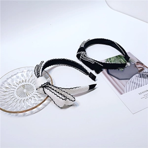 Detail view of black and white woven bow headbands with contrast wavy stitching