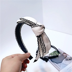 Elegant black and white knit headband featuring a stylish contrast bow hair accessory