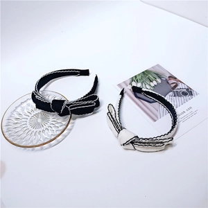 Detail of knit bow headbands with wavy contrast stitching on white background