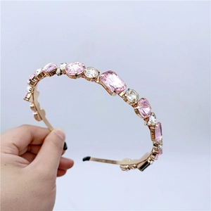 Detailed close-up of pink and clear crystals set on a gold-plated elegant headband