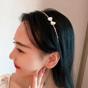 Detail of luxury thin headband with crystal heart bow design on silver metal base