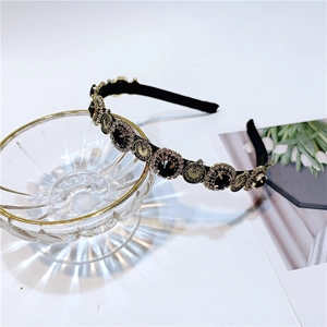 Detail of vintage French headband with golden clock dials and black crystal ornaments