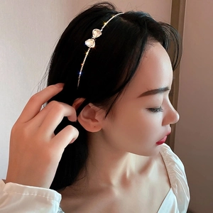 Close-up of a delicate silver headband featuring a sparkling rhinestone bow on a female model