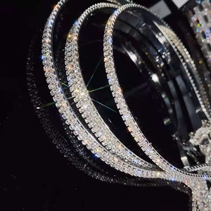 Vue rapprochée de trois serre-têtes argentés avec strass brillants sur un fond noir élégant