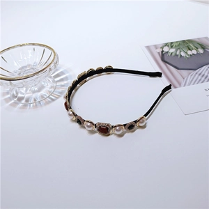 Close-up of baroque pearl and gemstone headband with golden metal settings