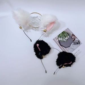 Détail d'oreilles de chat en peluche avec nœuds en soie et clochettes dorées