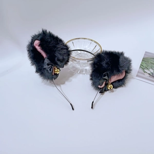 Détail des oreilles de chat en peluche noire avec doublure rose et clochettes dorées
