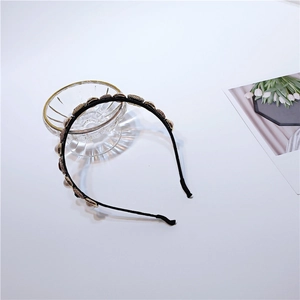 Close-up of vintage Baroque headband with white pearls and golden textured accents