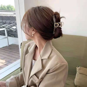 Dettaglio della pinza per capelli tartarugata con inserti dorati per uno chignon