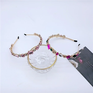 Detail view of gold luxury headbands with sparkling pink and multicolored crystals