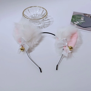 Détail du serre-tête oreilles de chat en peluche blanche avec nœuds et clochettes dorées