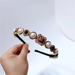 Detailed macro view of vintage Baroque headband with pearls and brown marbled stones