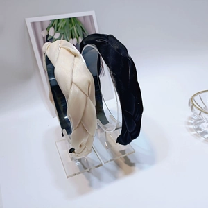 Dettaglio di cerchietti intrecciati a mano in raso beige e nero con trama elegante