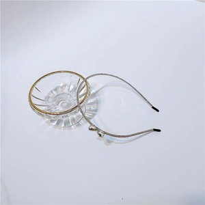 Detail view of thin silver metal headband with sparkling rhinestones and crystal bow