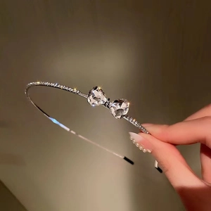 Elegant silver hairband featuring sparkling rhinestones and crystal heart bow design