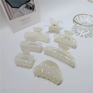 Set of iridescent white acetate hair claws in butterfly and geometric shapes on white background