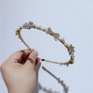 Detail of gold headband with faux pearls, rhinestones and sparkling butterfly ornaments
