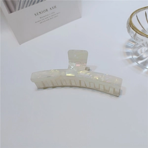 Detail of mermaid pearl acetate hair claw clip with iridescent finish and combs