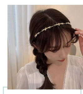 Elegant gold headband featuring white petal beads and crystals on a female model