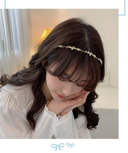 Detail of elegant gold floral headband with white petals and crystals on model