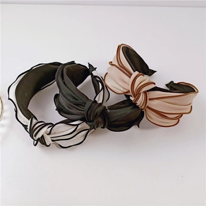 Close-up of knot headbands with satin texture and contrast piping in three colors