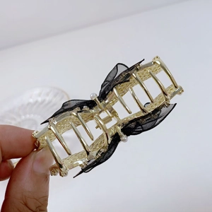 Pince à cheveux dorée avec nœud en dentelle noire et perles pour coiffure élégante de femme