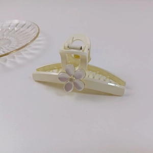 Détail de la pince à cheveux crème avec fleur de perle et ressort métallique