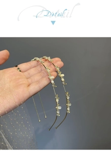Detail of two gold metal headbands with white flower petals and small rhinestones