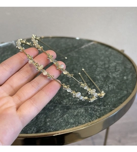 Detailed shot of golden headband featuring metallic butterflies and white cat-eye stones