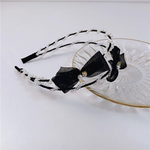 Elegant double-row headband featuring black mesh bows and white pearls on golden tray