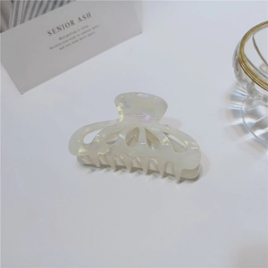 Close-up of cream white hollow petal hair claw clip with pearlescent acetate texture