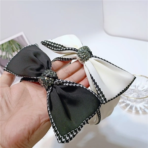 Details von Schleifenstirnbändern mit Hahnentritt-Muster und grauen Strasssteinen