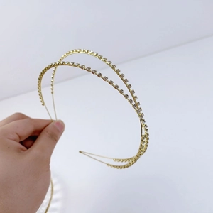 Dettaglio ravvicinato del cerchietto dorato a doppio strato con strass brillanti e lucenti