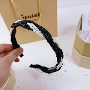 Detail van een handgemaakte gevlochten haarband met parels in elegant zwart en wit