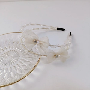 Detailed view of mesh bows with pearls and crystals on a double-layer headband