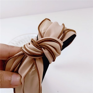 Elegant apricot pleated wide headband with dark brown trim and center knot design