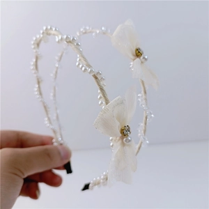 Detail of double row cream mesh bow headband set with crystals and imitation pearls