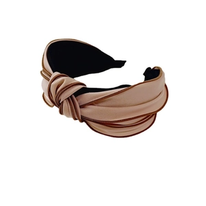 Elegant beige wide knotted headband with dark brown piping on white background