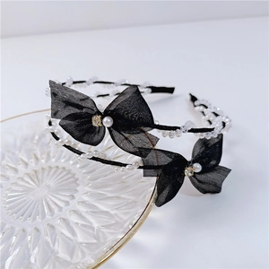 Close-up of double-row headband with mesh bows and crystal beads on glass tray