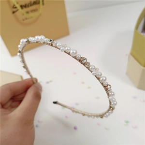 Dettaglio del cerchietto sottile con perle, cristalli sfaccettati e filo d'oro intrecciato