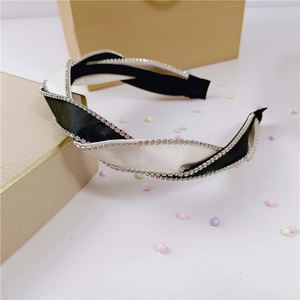 Detail of twisted knot headband featuring black and white satin with sparkling rhinestones