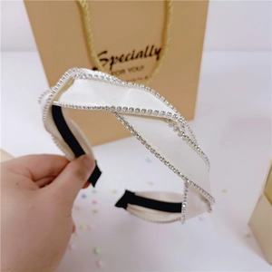 Detail of twisted white satin headband with sparkling rhinestones and black anti-slip inner lining