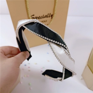 Detail of knot headband featuring black and white satin fabric and sparkling rhinestones